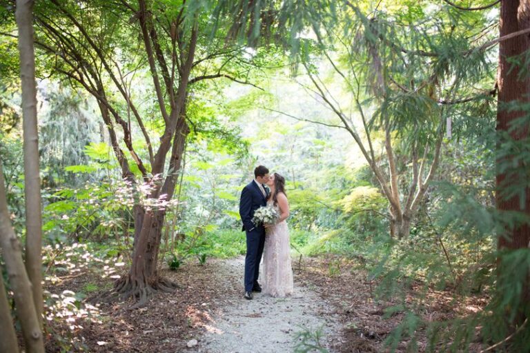 Bride and Groom embrace in Duke Gardens in BHLDN dress and Navy Menguin suit with golden sun Duke Gardens wedding by Gather Together Photography by Katherine Miles Jones (1)