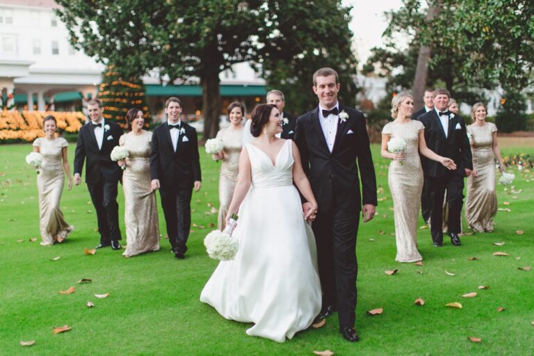 Bridal party in champagne gold and black tuxedos in front of venue at Pinehurst Resort, Mary Me