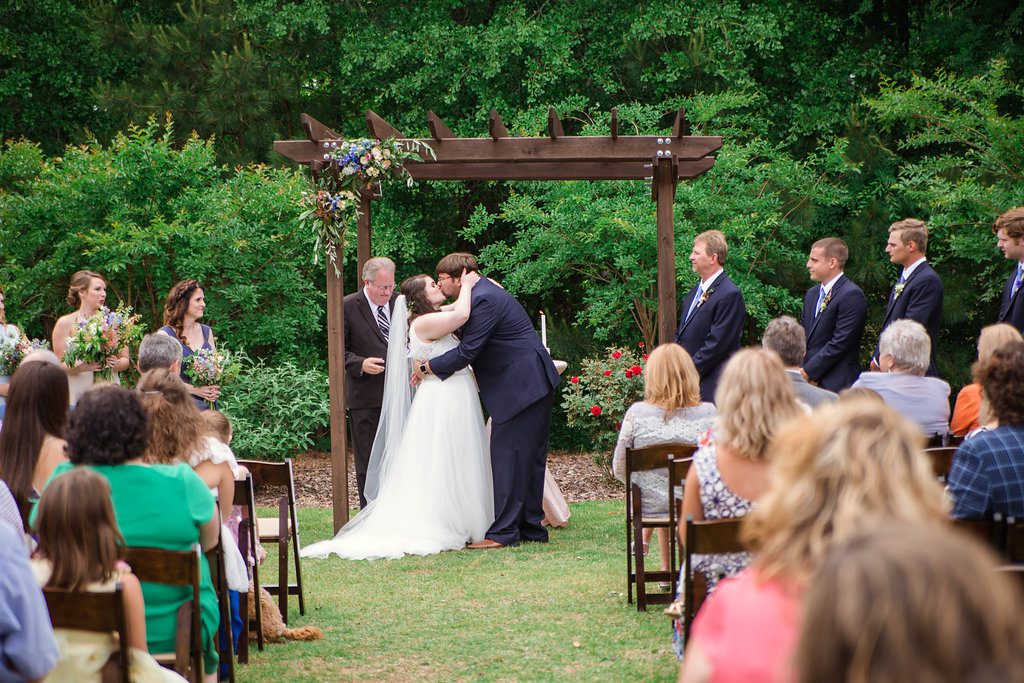 Bride and Groom's first kiss under alter at The Bradford, Raleigh Wedding Venue, Johanna Dye